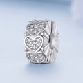 Silver charm with heart designs on a light blue background