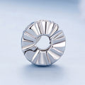 Silver ring with a textured design on a light blue background