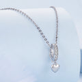 Silver heart-shaped pendant necklace on a light blue background
