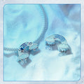 Silver necklace with cloud and rainbow pendants on a soft blue fabric background