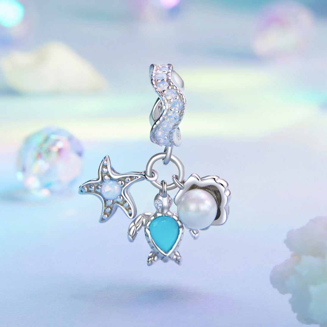 Silver earring with star, moon, and heart charms on a soft, multicolored background