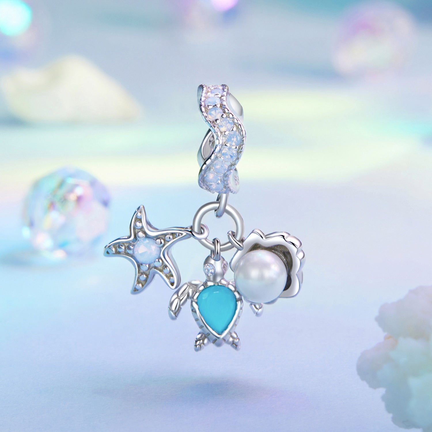 Silver earring with star, moon, and heart charms on a soft, multicolored background