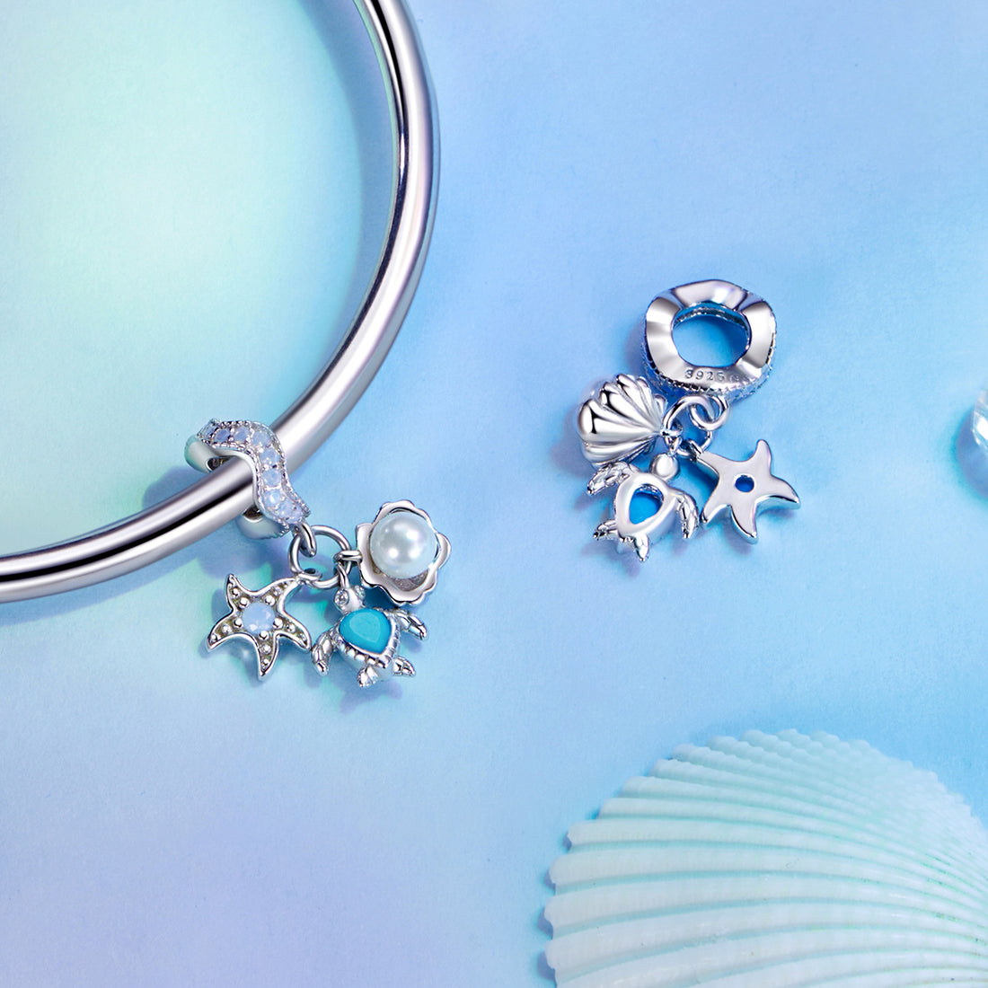Silver earring with star, moon, and heart charms on a soft, multicolored background