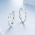 Silver hoop earrings on a light blue background