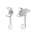 Silver moon-shaped earrings with clear gemstones and pearls on a white background
