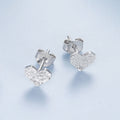 Silver heart-shaped earrings on a light blue background