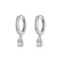 Silver hoop earrings with square drop charms on a white background