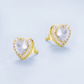 Heart-shaped earrings with clear gemstones and gold accents on a light blue background