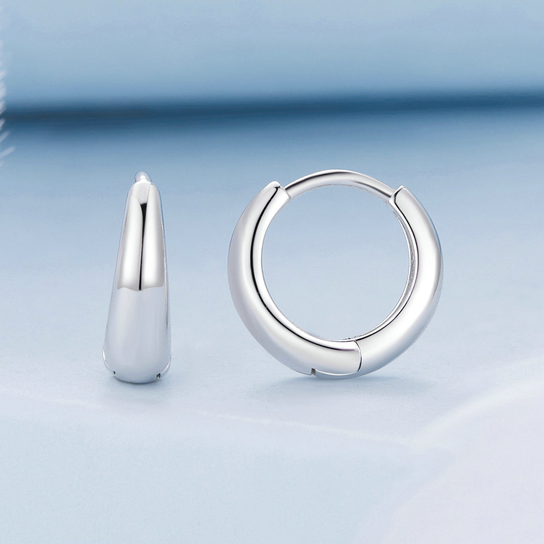 Pair of silver hoop earrings on a white background