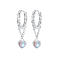 Silver hoop earrings with heart-shaped charms on a white background