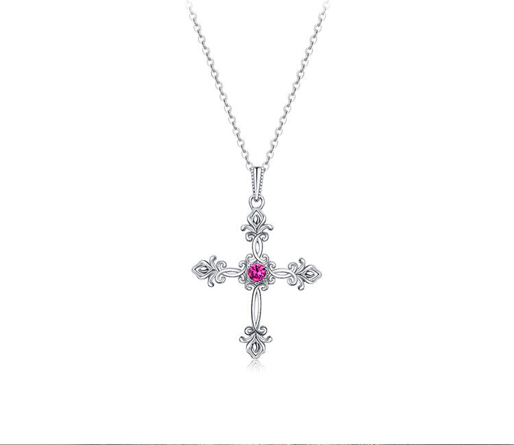 Silver cross necklace with a pink gemstone on a white background, featuring the text 'As Unique As You'.