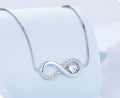 Silver infinity necklace with a heart pendant on a light blue background