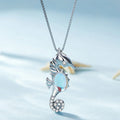 Seahorse-shaped necklace with a blue gemstone on a light blue background