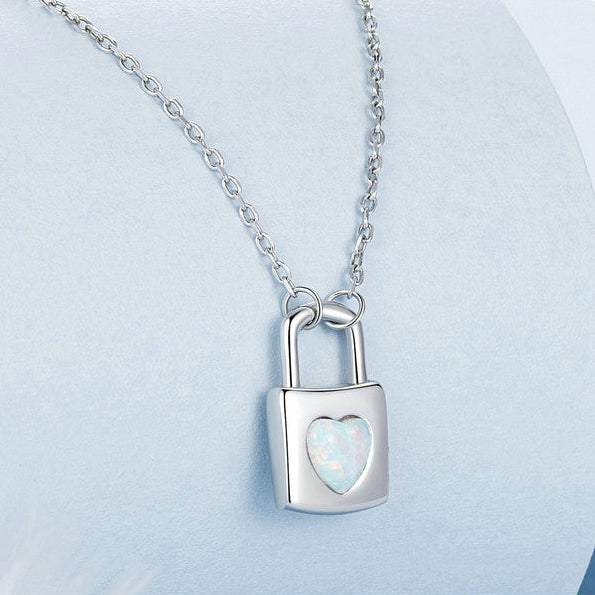 Silver necklace with a lock-shaped pendant on a light blue background