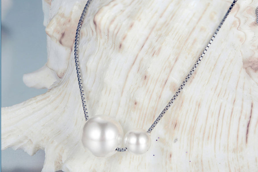 Pearl necklace with a shell on a light blue background