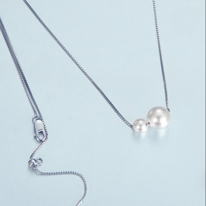 Pearl necklace with a shell on a light blue background