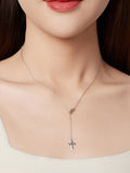 Necklace with a cross pendant worn by a person, with a neutral background