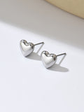 Heart-shaped silver earrings on a light background