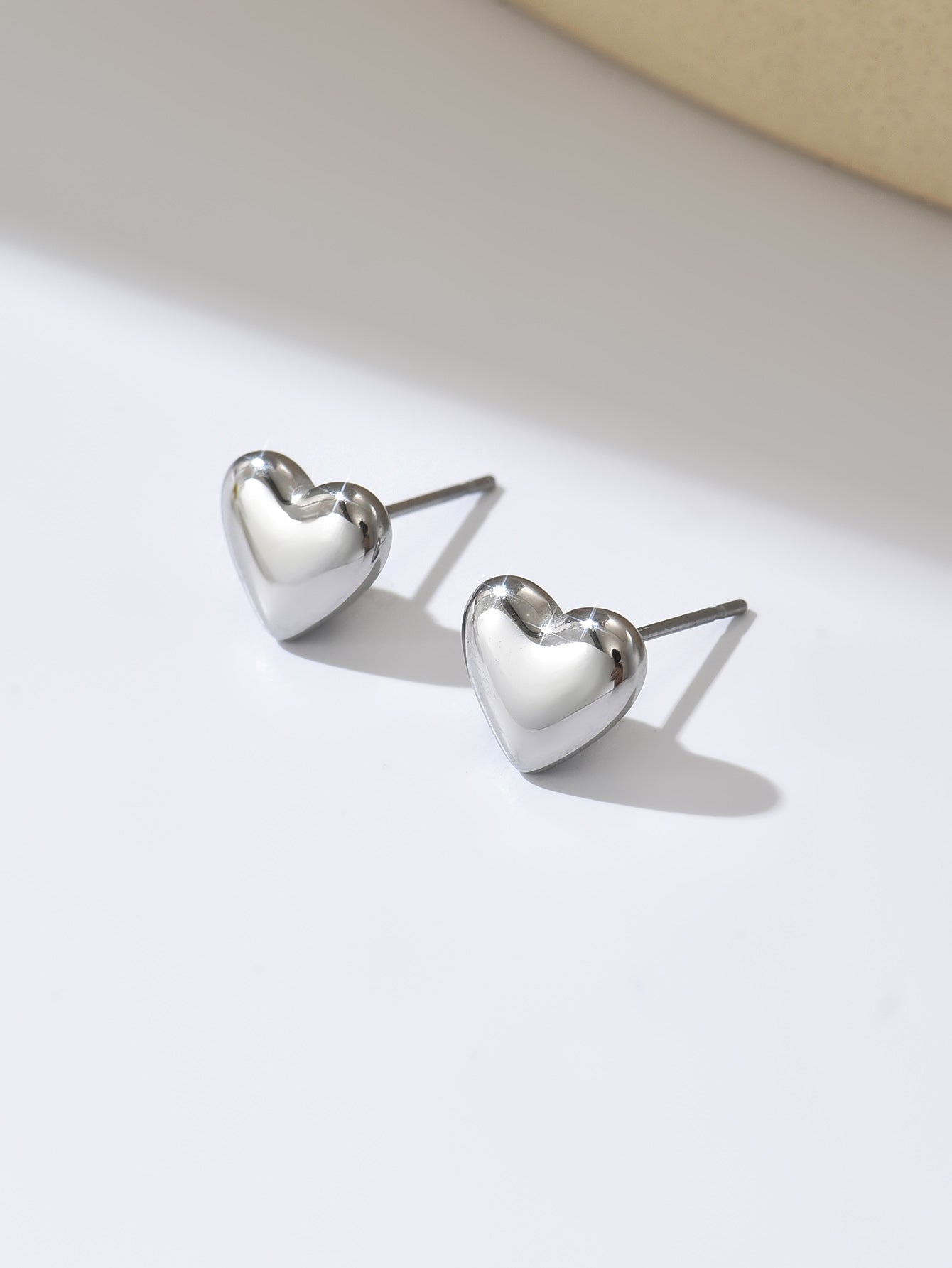 Heart-shaped silver earrings on a light background