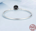 Silver bracelet with a black gemstone on a light blue background, featuring 'Real Sterling Silver' stamp.