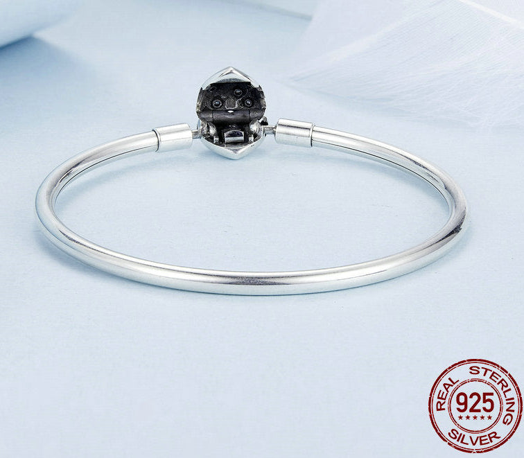 Silver bracelet with a black gemstone on a light blue background, featuring 'Real Sterling Silver' stamp.