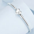 Silver bracelet with a heart-shaped clasp on a light blue background