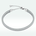 Silver bracelet with a textured band on a white background