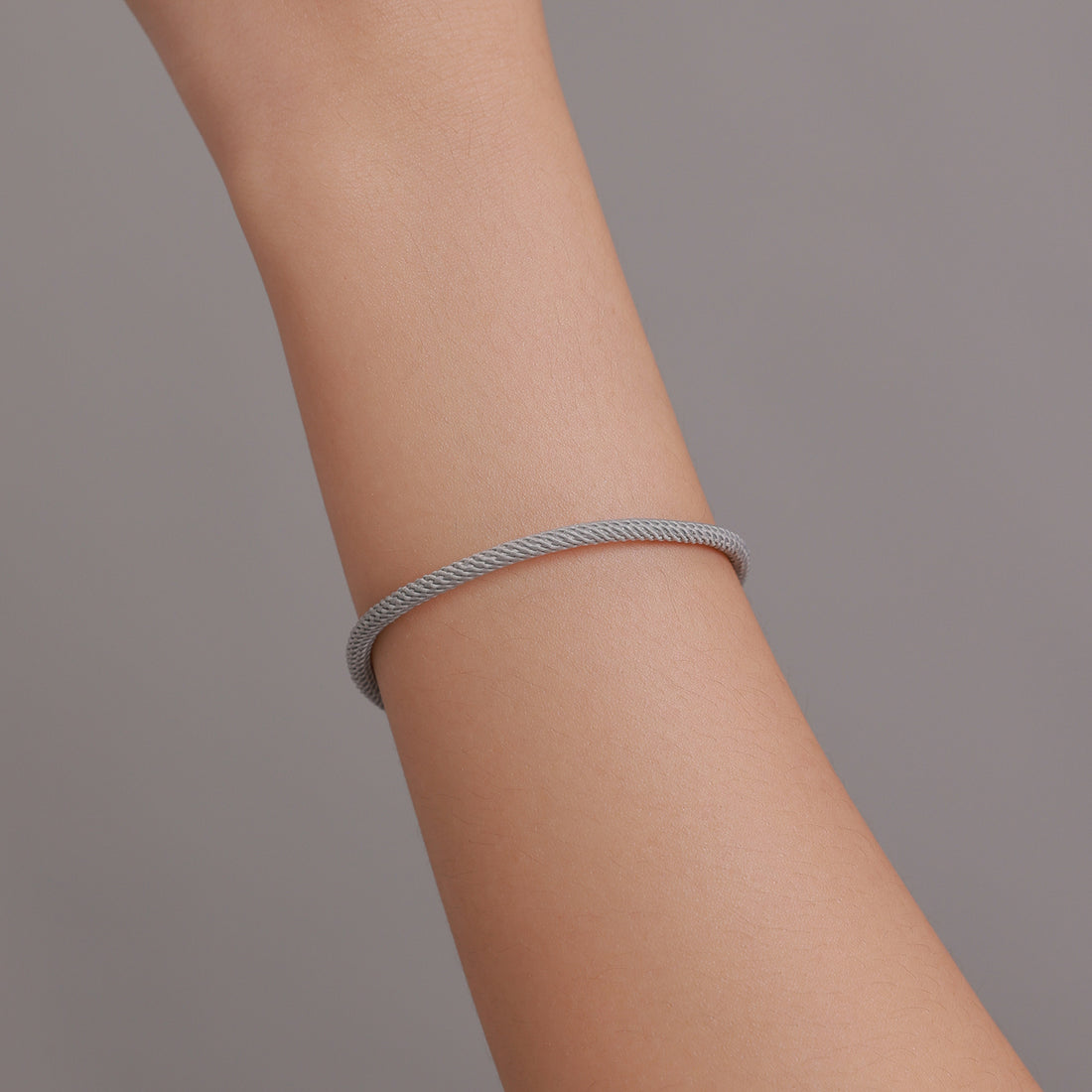 Silver bracelet with a textured band on a white background