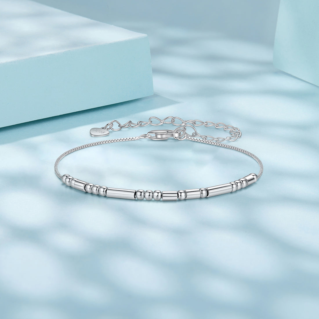 Silver bracelet with cylindrical beads on a white background