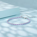 Silver bracelet with purple beads on a light blue background