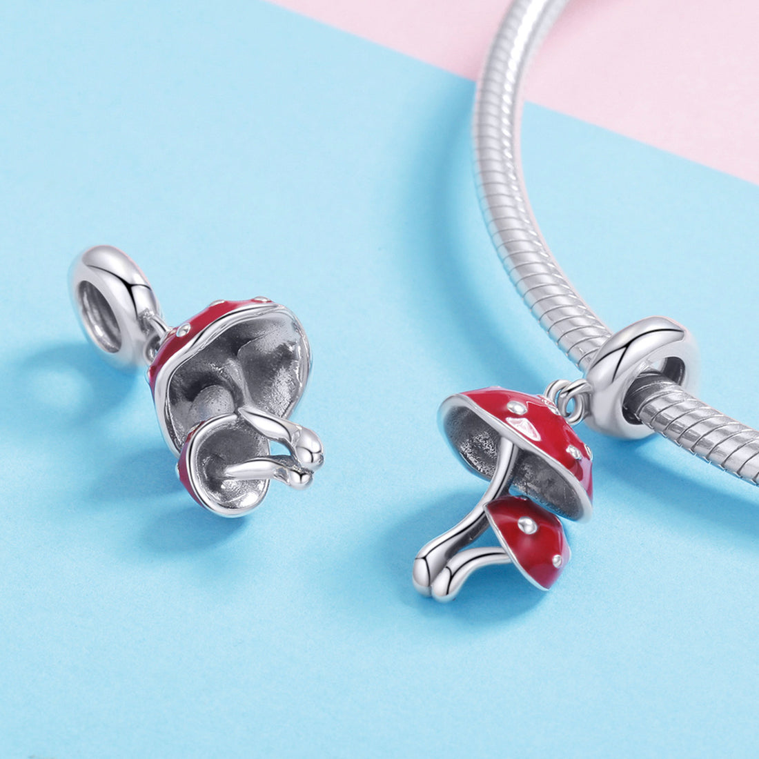 Red mushroom-shaped pendant with silver accents on a light blue and white background