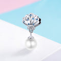 Pearl charm with shell design and blue stones on a colorful background