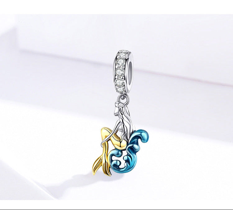 Jewelry charm with gold and blue design on a white background