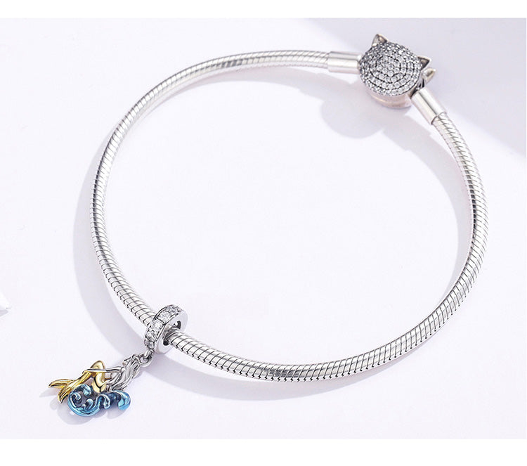 Jewelry charm with gold and blue design on a white background