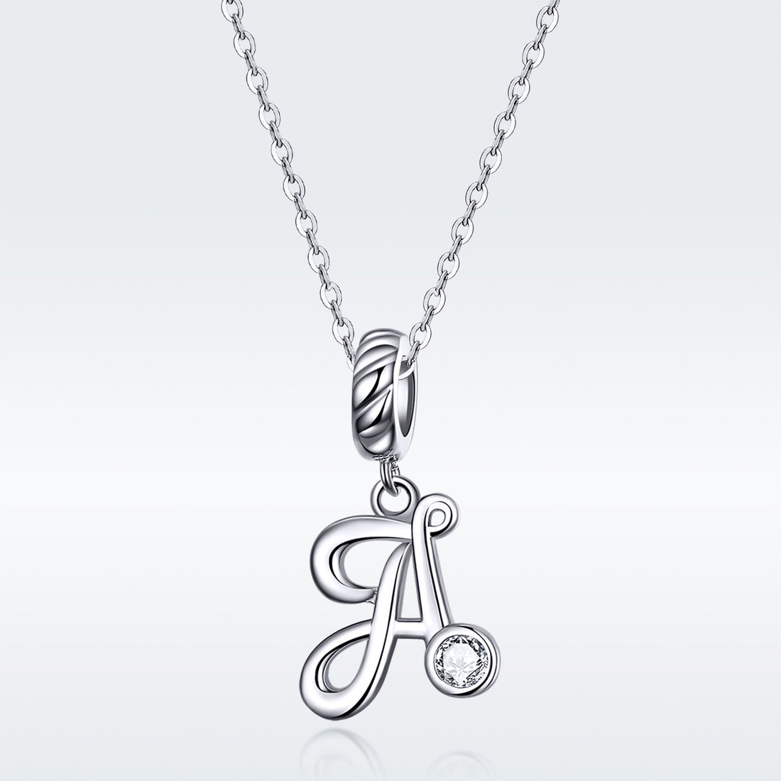 Silver pendant with letter 'A' and small round gemstone on a light gray background