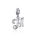 Silver pendant with letter 'M' and clear gemstone on a white background