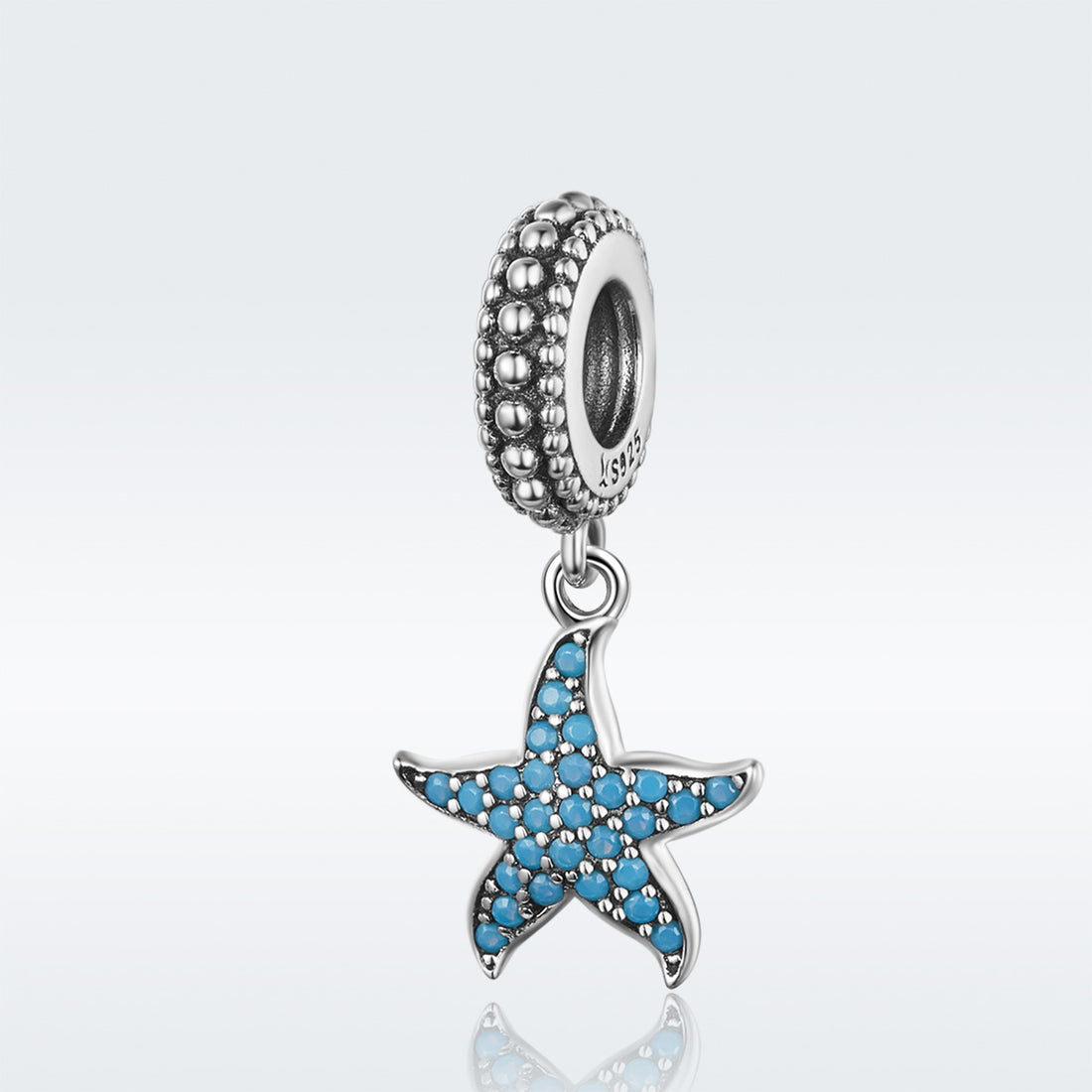 Silver charm with a blue star design on a light gray background