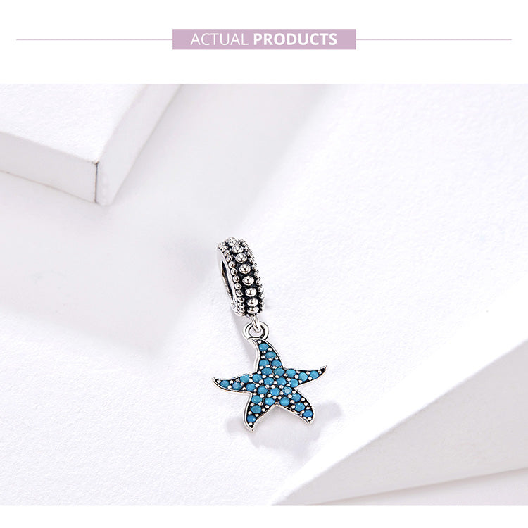 Silver charm with a blue star design on a light gray background