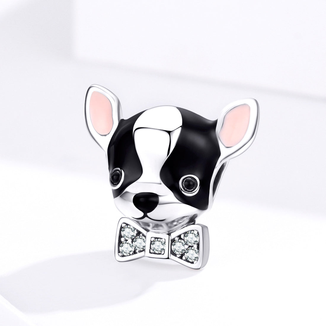 Dog-shaped charm with a bow tie on a white background