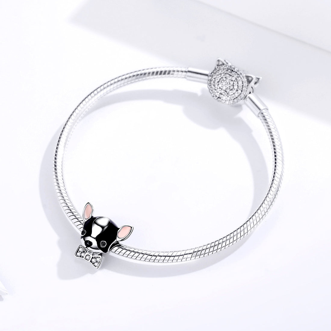 Dog-shaped charm with a bow tie on a white background