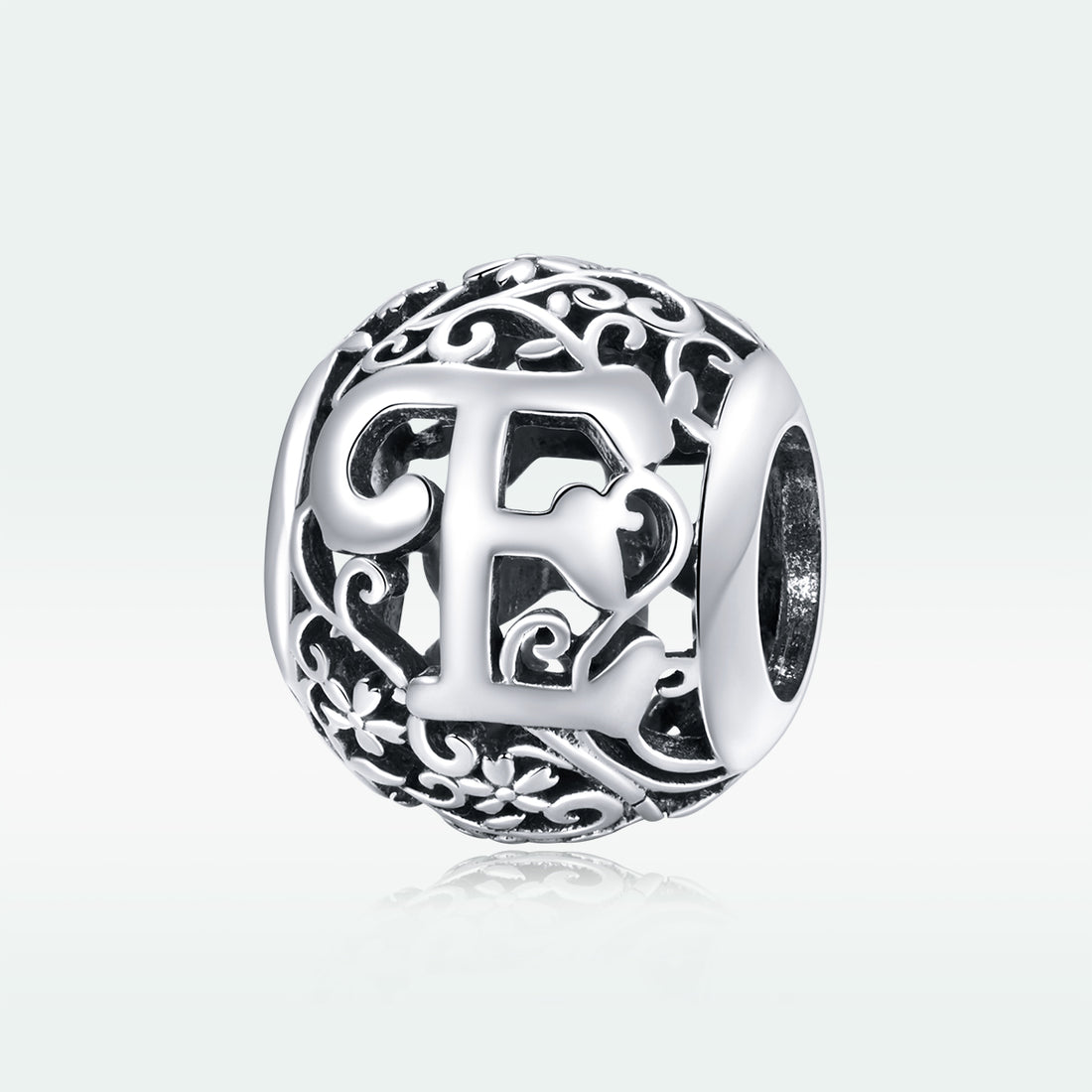 Silver charm with intricate design and letter 'E' on a white background