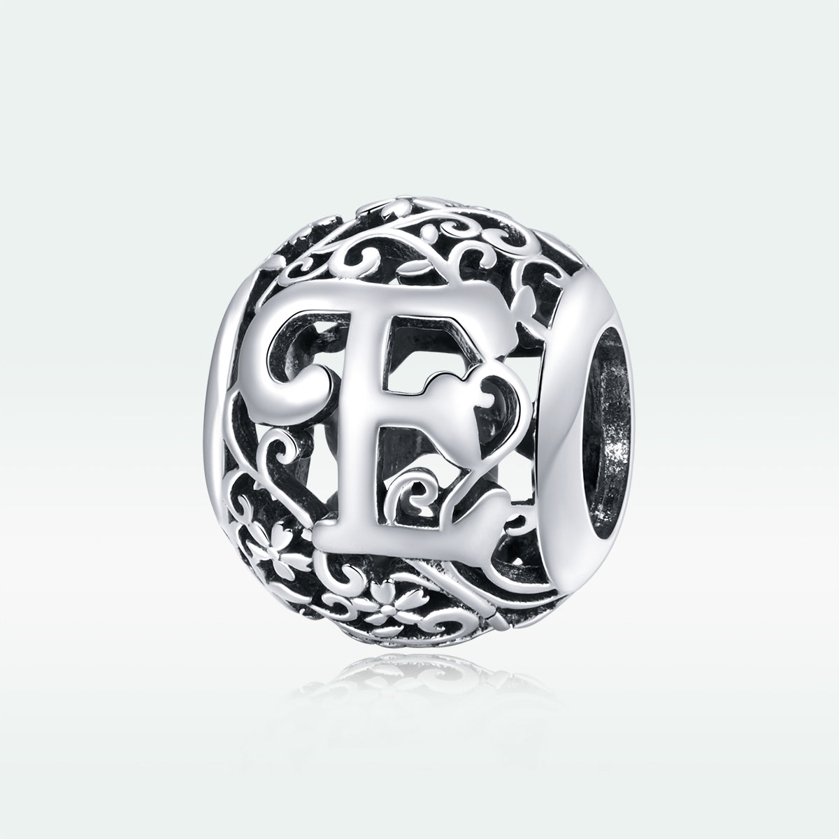 Silver charm with intricate design and letter 'E' on a white background