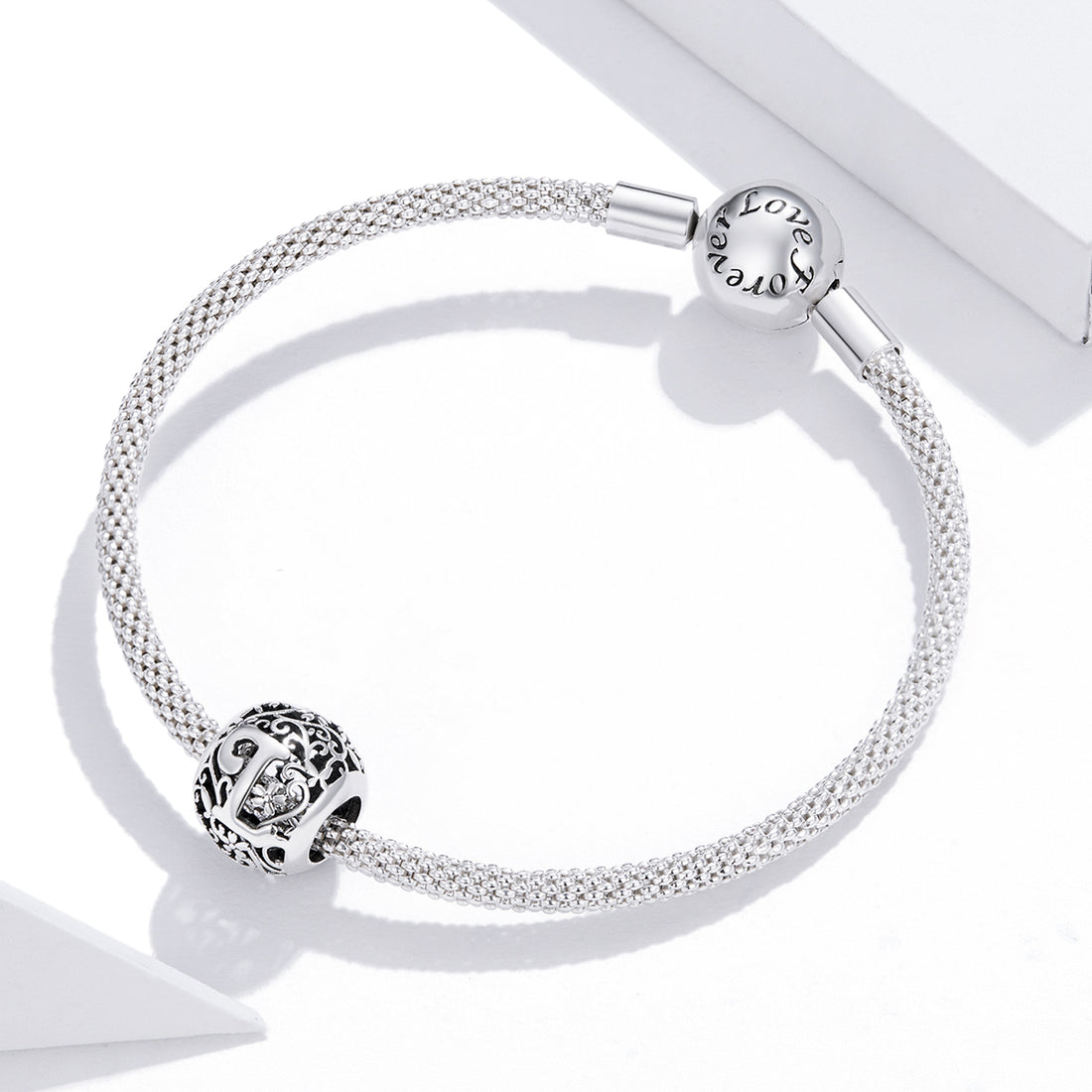 Silver bracelet with charms on a white background