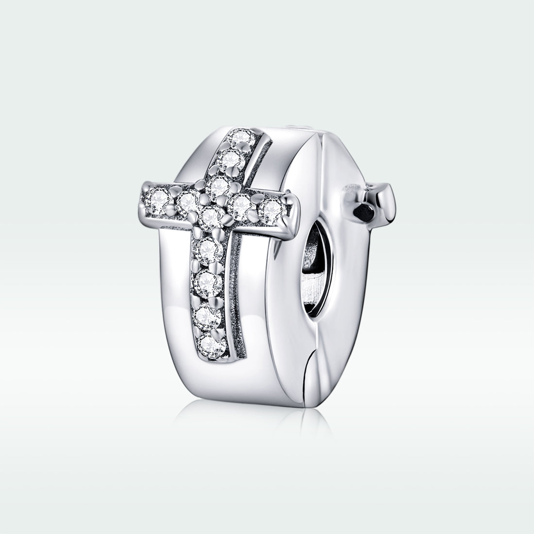 Silver cross charm with clear stones on a white background