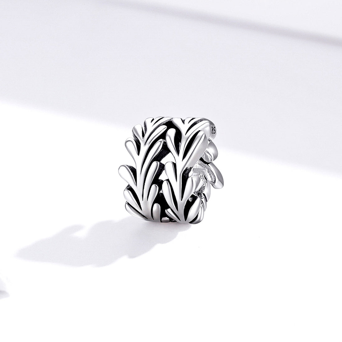 Silver leaf-shaped charm on a white background
