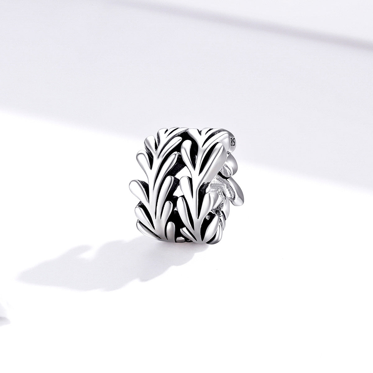 Silver leaf-shaped charm on a white background