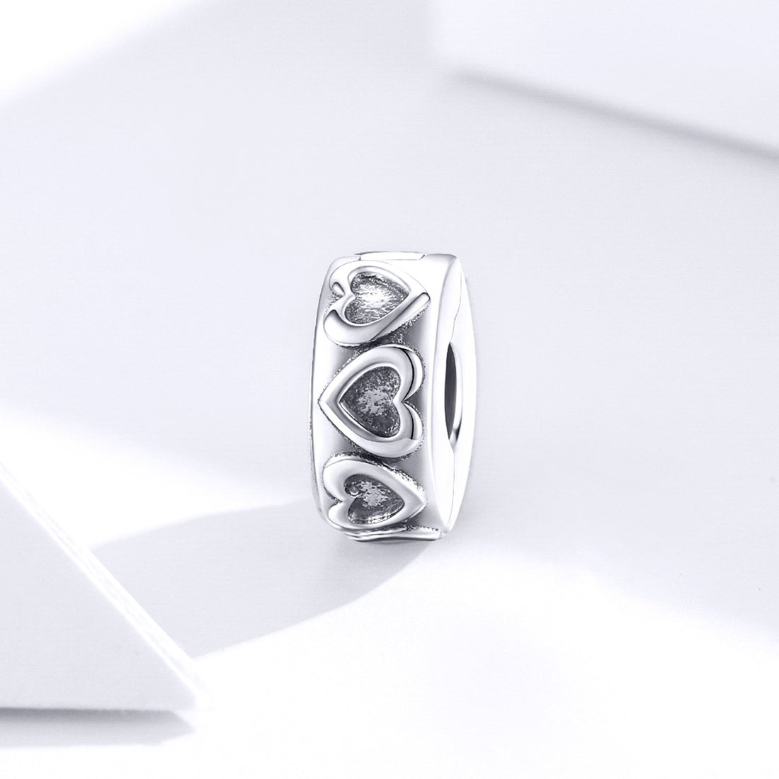 Silver ring with heart designs on a white background