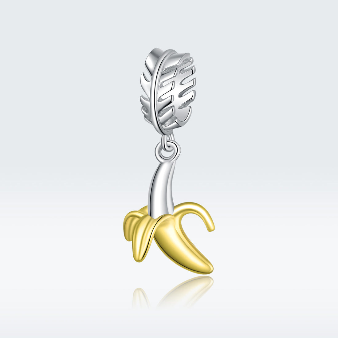 Silver and gold banana-shaped charm on a white background