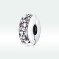 Silver charm with pink and clear stones on a light gray background