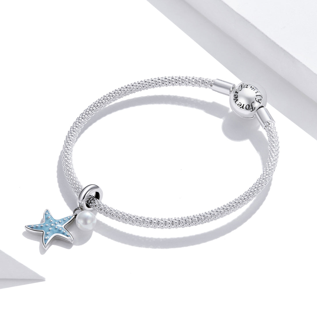 Starfish and pearl charm on a white background
